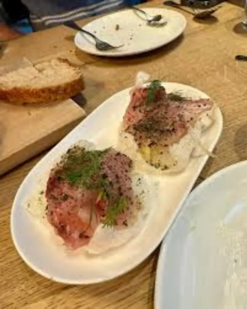 Carpaccio de pește: poza de telefon, pe masa de lemn cu pâine alături, și varianta pe fundal deschis. Feliile, verdeața și farfuria sunt aceleași., înainte